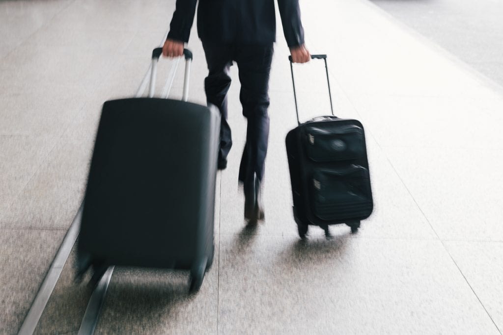 Businessman hurrying with two suitcases