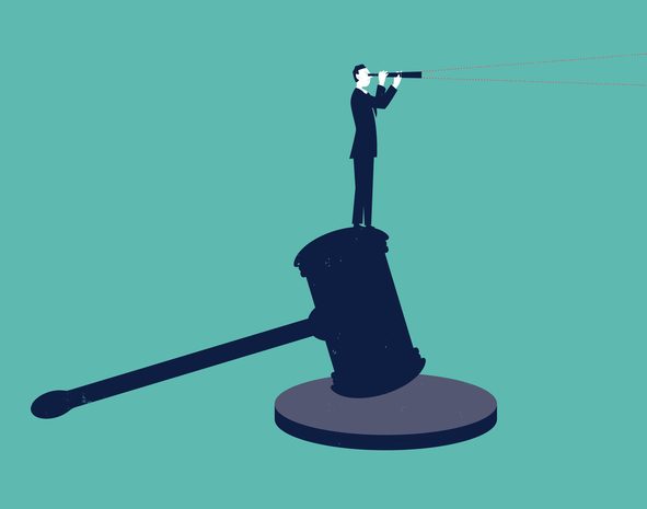 Businessman standing on a hammer of justice with spyglass