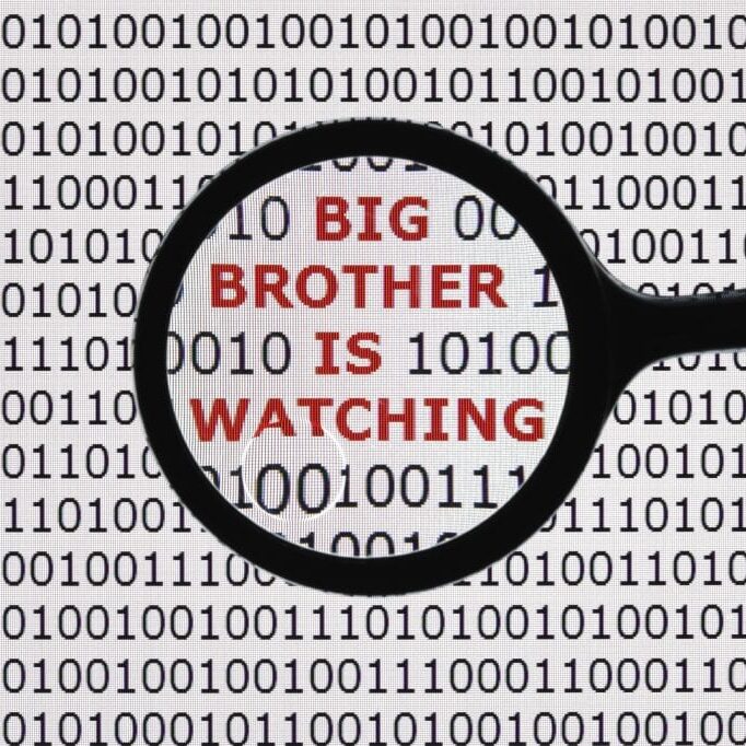 Internet security concept the words big brother is watching on a digital tablet screen with a magnifying glass