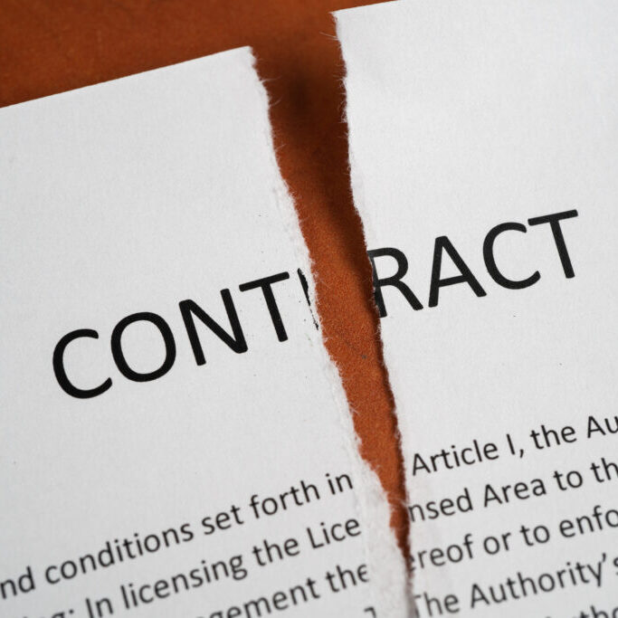 Close up of torn up contract on a wooden desk