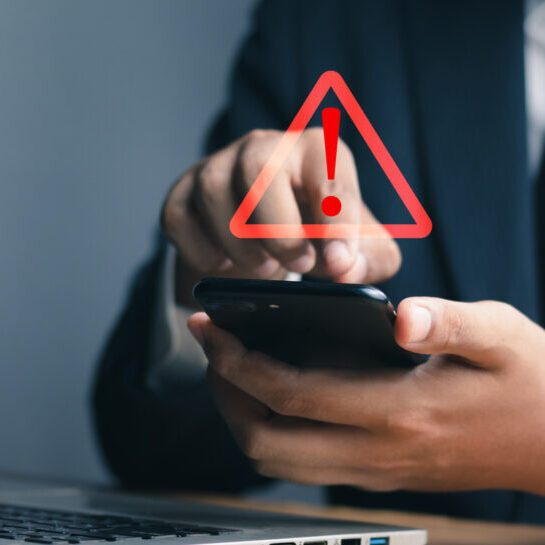 System warning hacked alert, cyber attack on computer network.Businessman using mobile phone with warning sign notification error, Malicious software,virus and cybercrime, Cybersecurity,data breach.