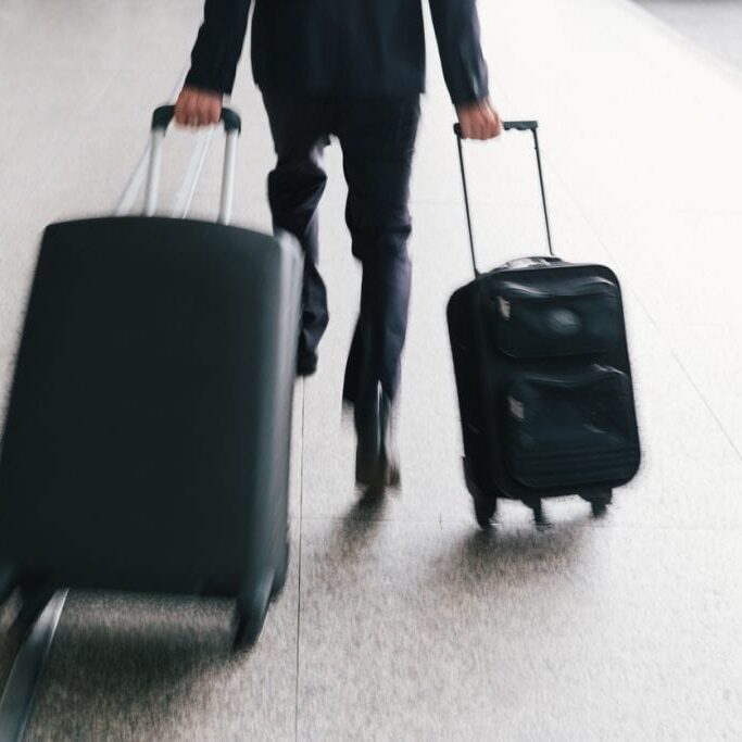 Businessman hurrying with two suitcases