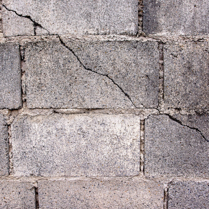 Crack in concrete cinder block wall background.Cement cinder block cracked wall
