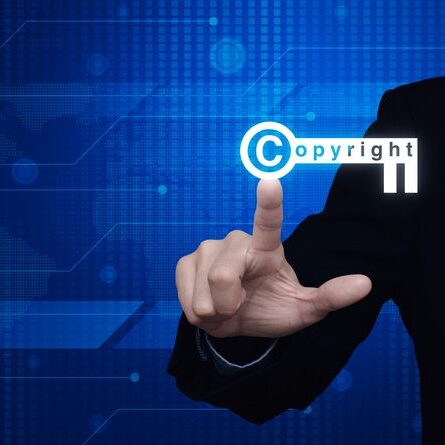 Businessman pressing copyright key icon over digital world map