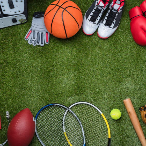 High Angle View Of Various Sport Equipments On Green Grass