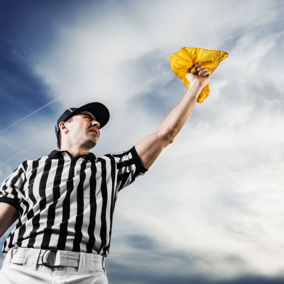 A football referee holding a yellow flag against the sky.  He is calling the penalty. 

[url=https://www.istockphoto.com/search/lightbox/9786766][img]https://dl.dropbox.com/u/40117171/sport.jpg[/img][/url]