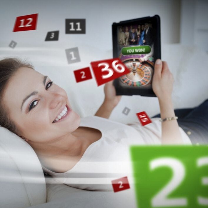Woman lying on couch and gambling on tablet with holographic numbers around her